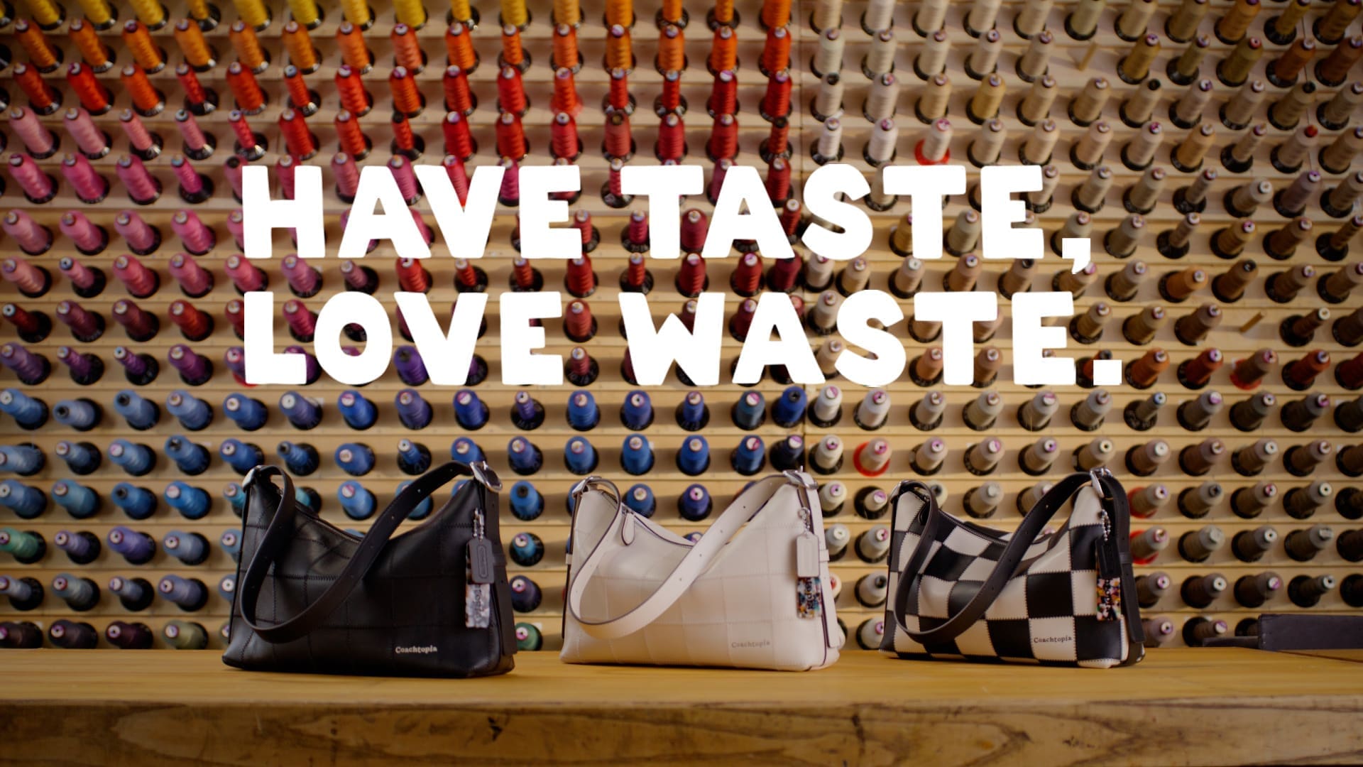 Three Coachtopia Alter/Ego bags in different colors, displayed in front of a colorful thread wall with the words ‘Have Taste, Love Waste.’