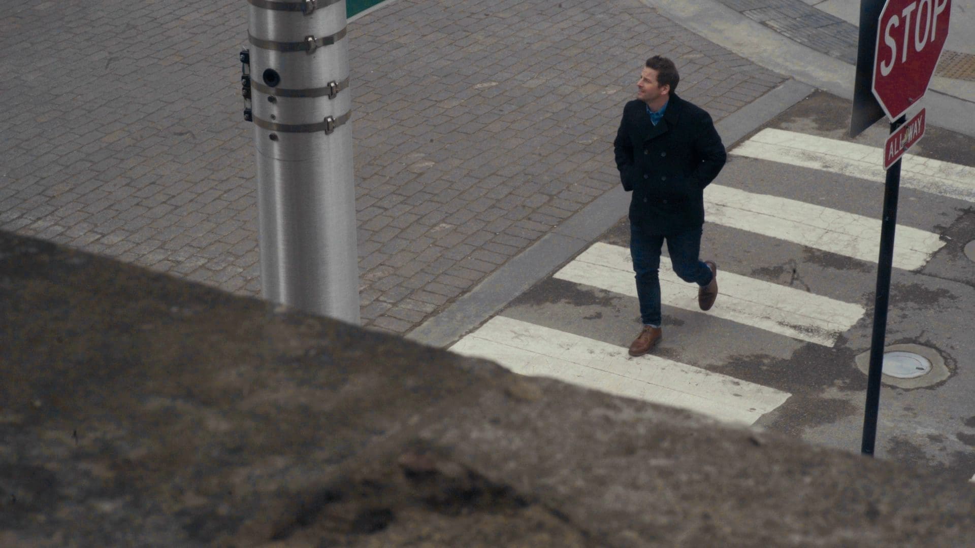 Jamie McDonald walking across a city street in Chicago, symbolizing the connection between finance, risk management, and everyday life.