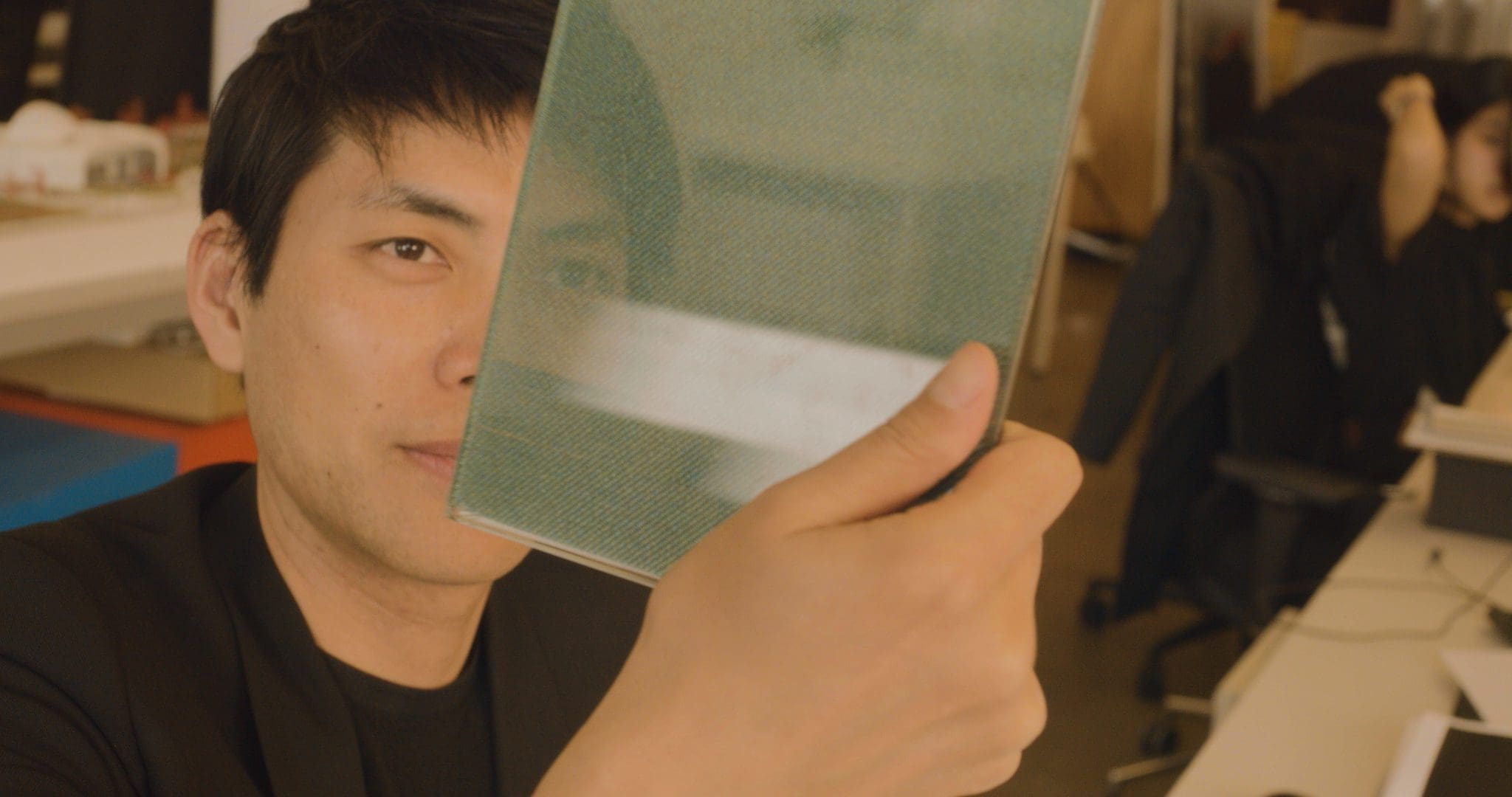 RIOT, NYC Creative Agency: Shohei Shigematsu, holding a piece of architectural material, demonstrating his hands-on approach to design and material selection. Shohei Shigematsu, holding a piece of architectural material, demonstrating his hands-on approach to design and material selection.