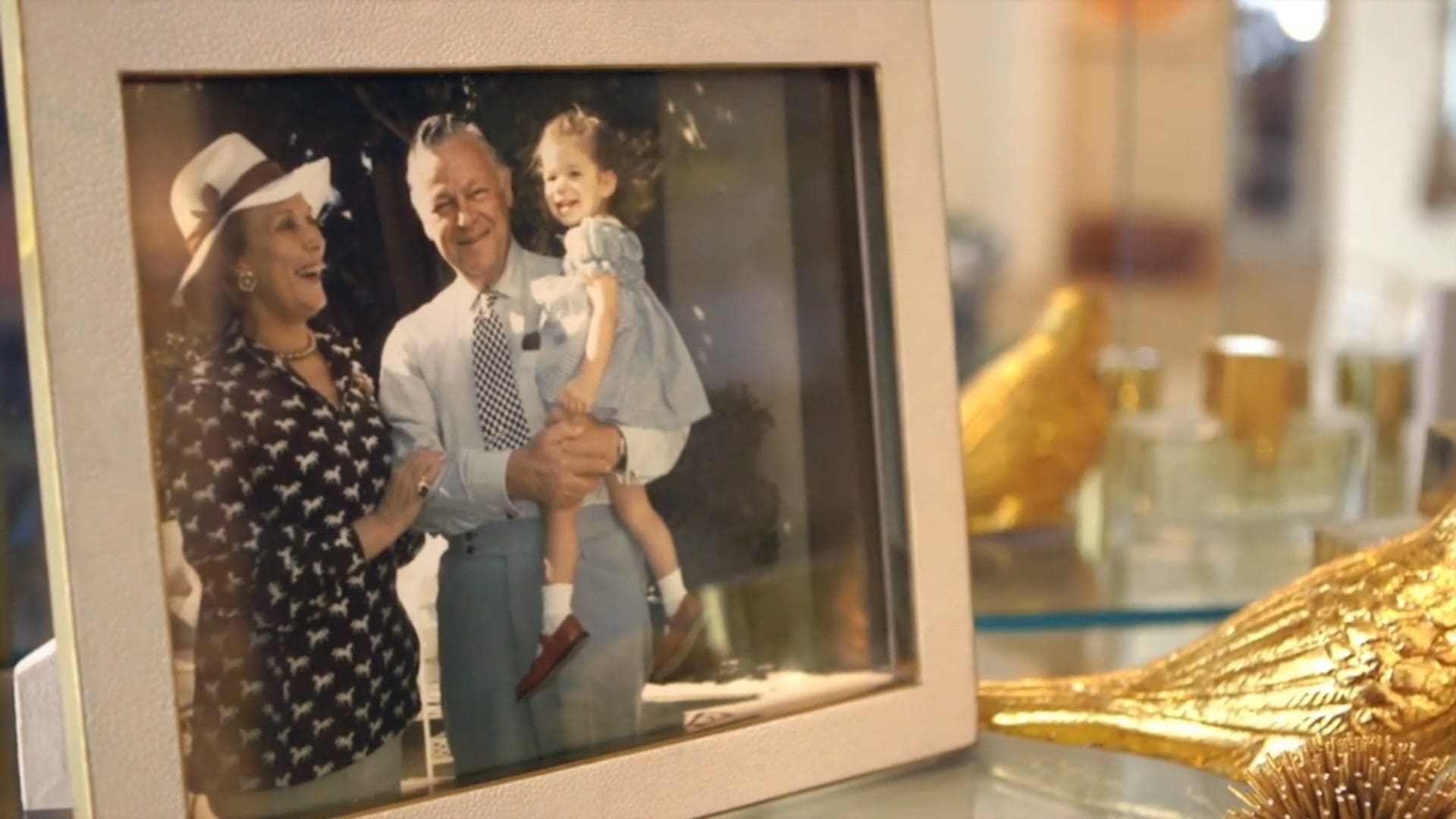 A staged vintage photo of Estée Lauder, her husband, and their daughter Jane Lauder, placed in a luxurious setting to evoke the essence of the Lauder family home.