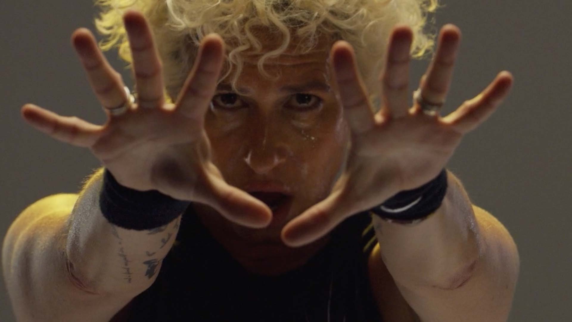 Melanie reaching forward with intensity during a SoulCycle class, symbolizing connection and dedication to her riders.