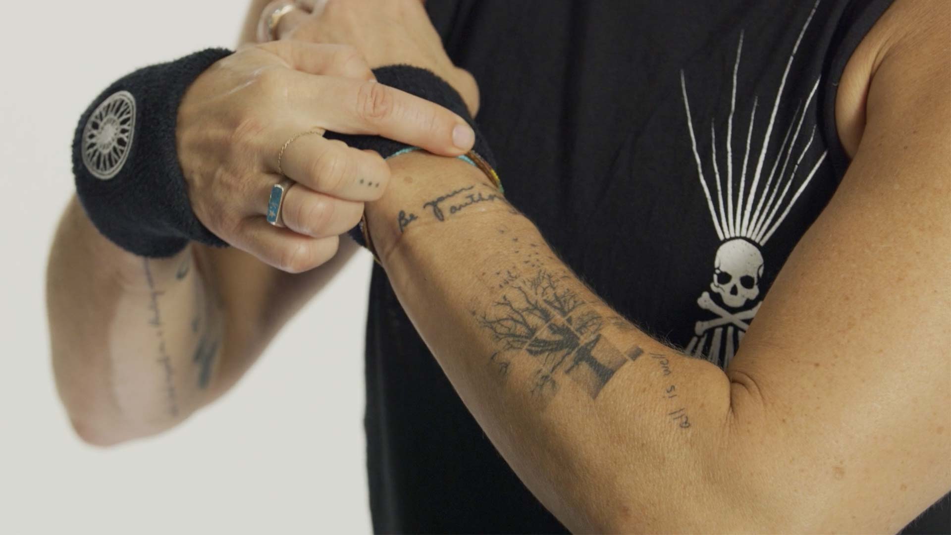 Close-up of Melanie’s forearm tattoo in her father’s handwriting, saying “Be your own authority,” symbolizing empowerment and personal strength.