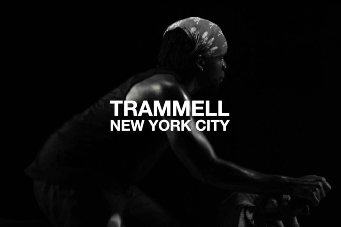 Trammell, a SoulCycle instructor, cycling in silhouette with “Trammell New York City” displayed over the image
