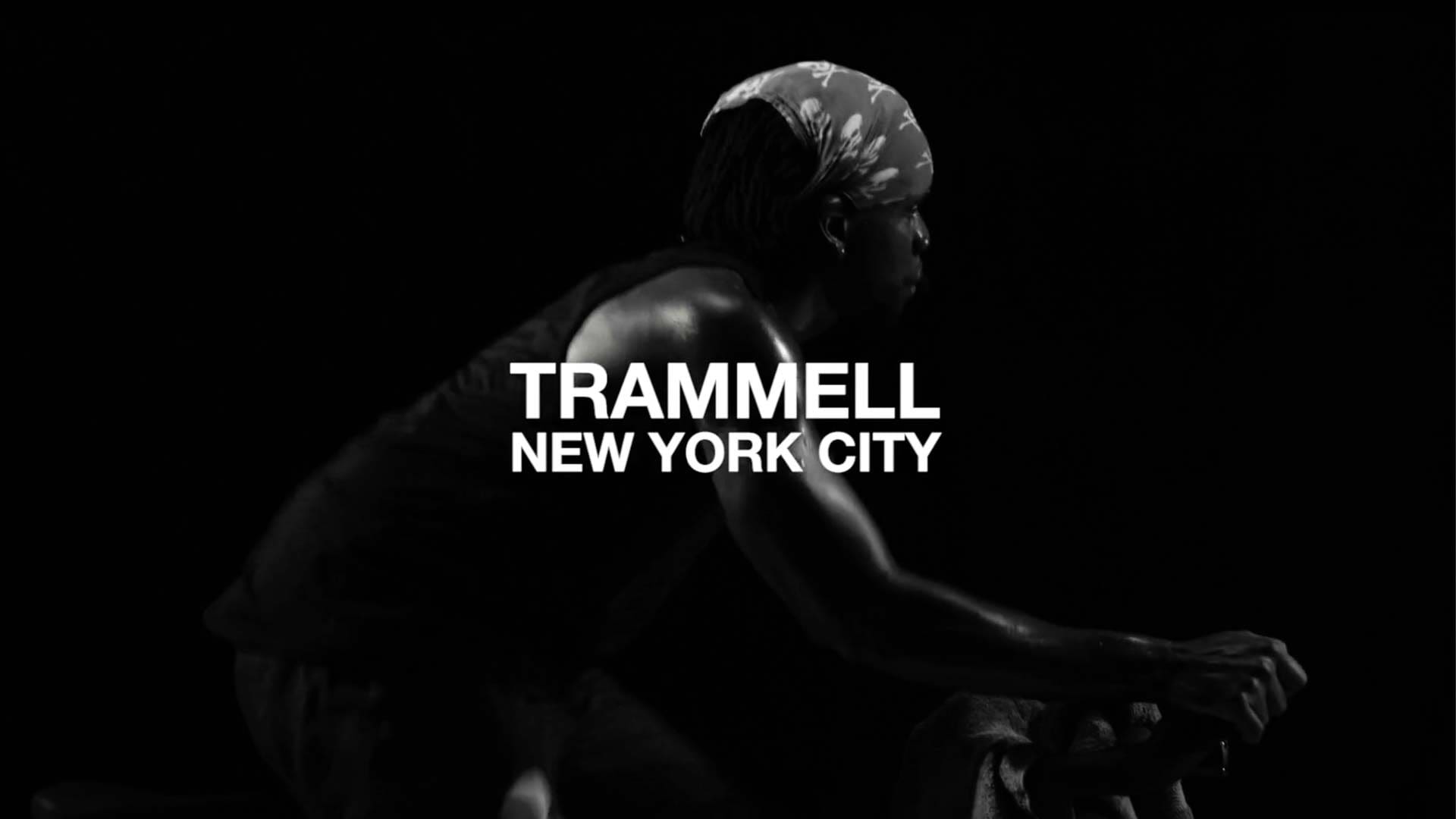 Trammell, a SoulCycle instructor, cycling in silhouette with “Trammell New York City” displayed over the image