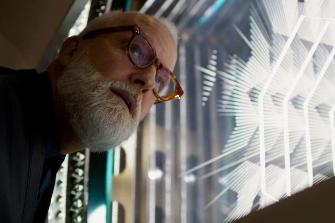 Christopher Young, Tiffany's VP Creative Director, intently observing the intricate holiday window display, highlighting a fusion of light and craftsmanship.