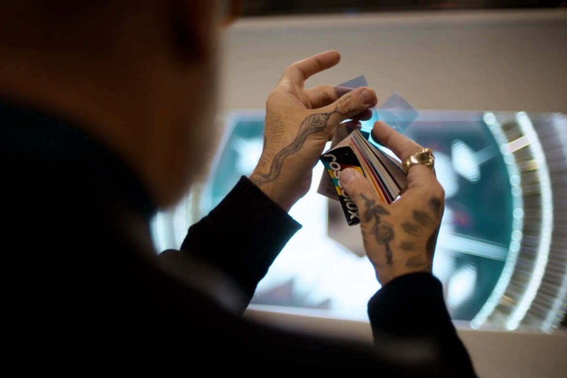Artisan's hands with tattoos carefully selecting colorful light filters for Tiffany & Co.'s holiday window display.