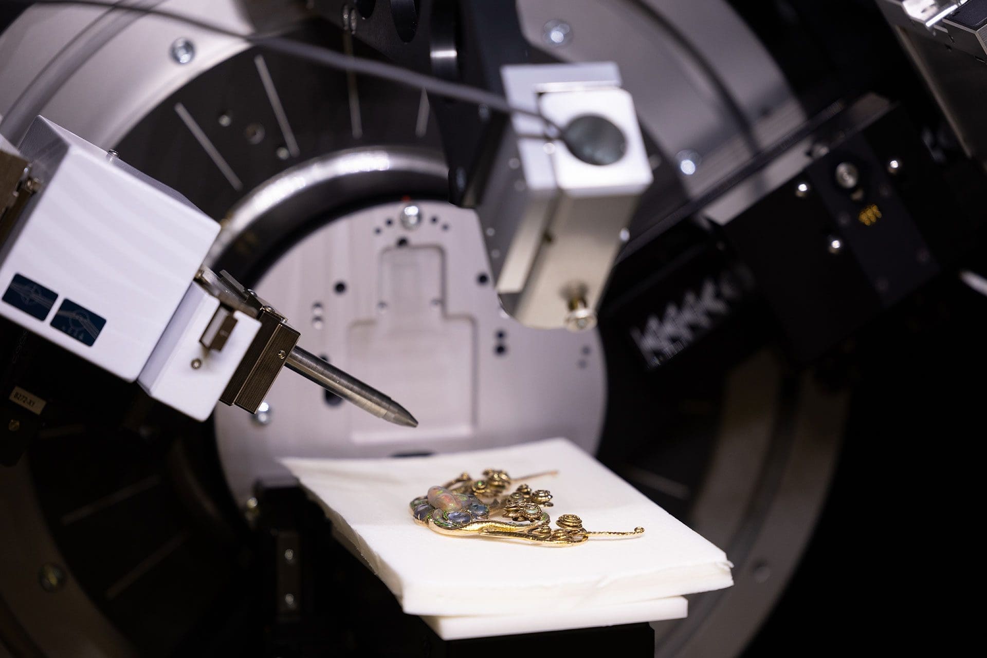 RIOT, NYC Creative Agency: High-precision jewelry crafting equipment with a piece of intricate gold jewelry placed on a white cloth, depicting the modern technology used in fine jewelry making at Tiffany & Co. High-precision jewelry crafting equipment with a piece of intricate gold jewelry placed on a white cloth, depicting the modern technology used in fine jewelry making at Tiffany & Co.