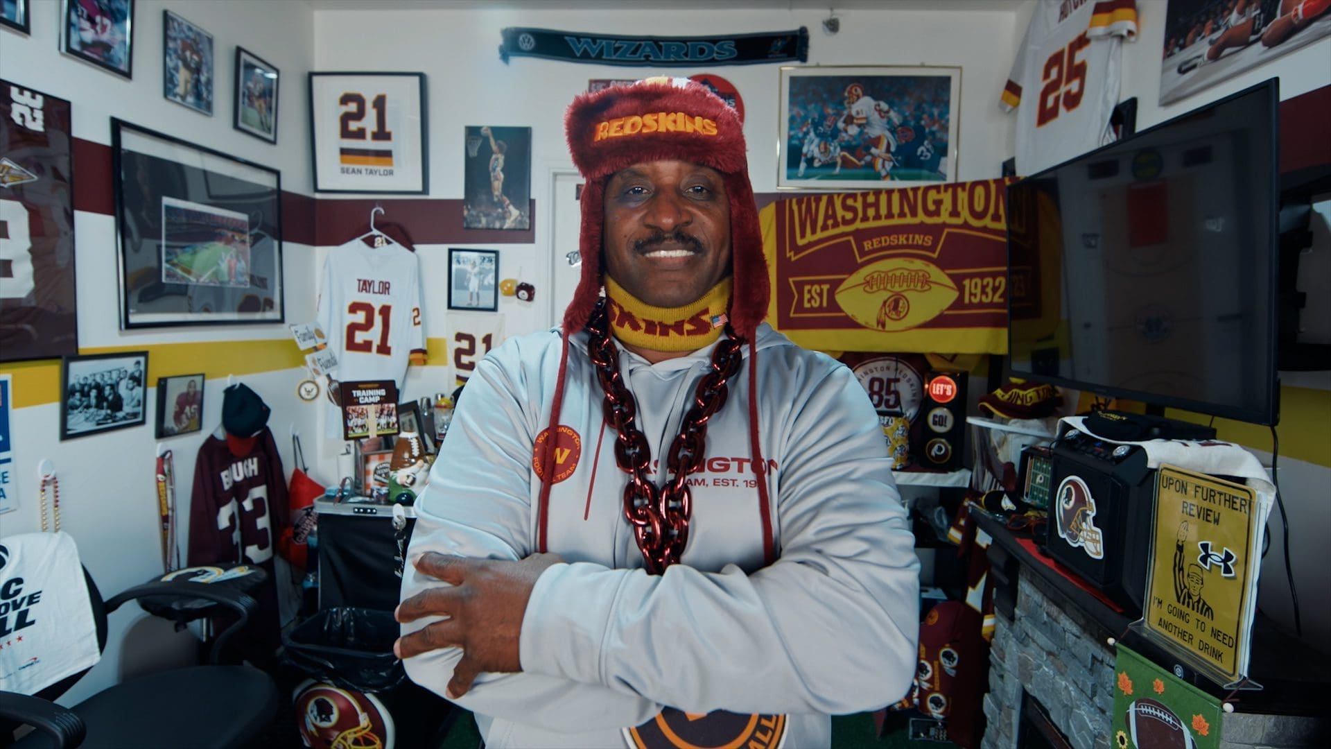 Washington Commanders superfan standing in a room filled with team memorabilia, celebrating the team’s legacy and rebrand.