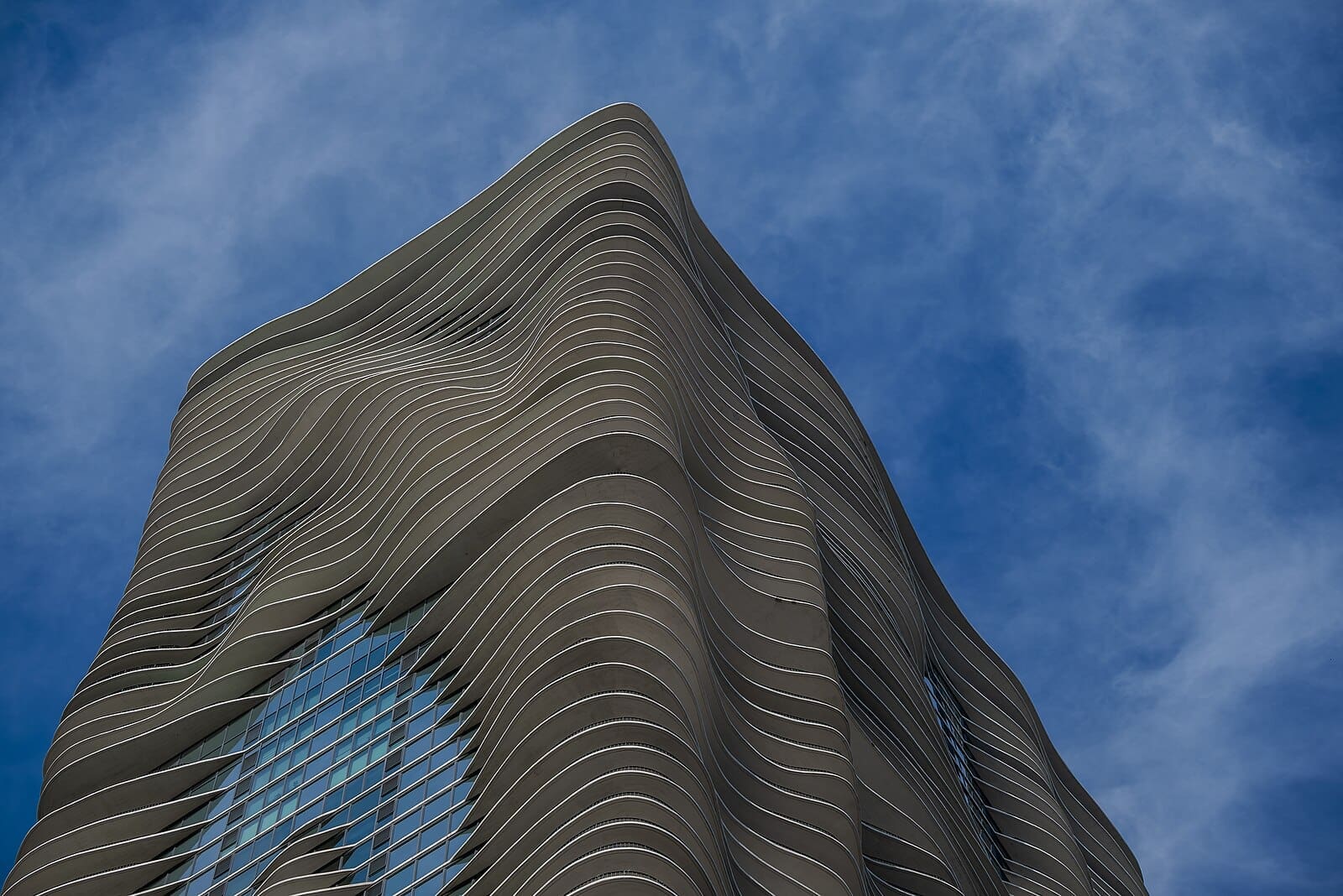 Aqua Tower in Chicago, designed by Jeanne Gang, showcasing its flowing, wave-like design against the sky.