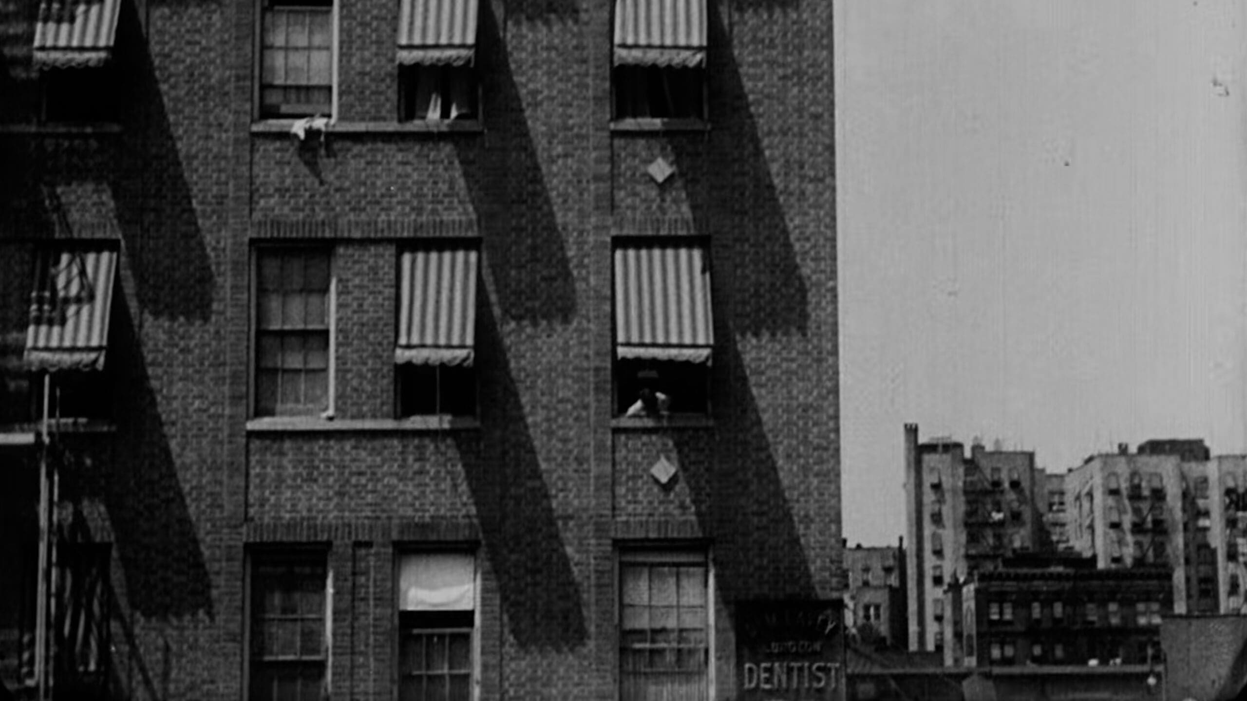 Archival black-and-white image of a Bronx apartment building from the 1940s, used in RIOT’s Bag Man film for Coach to represent Lew Frankfort’s early life.