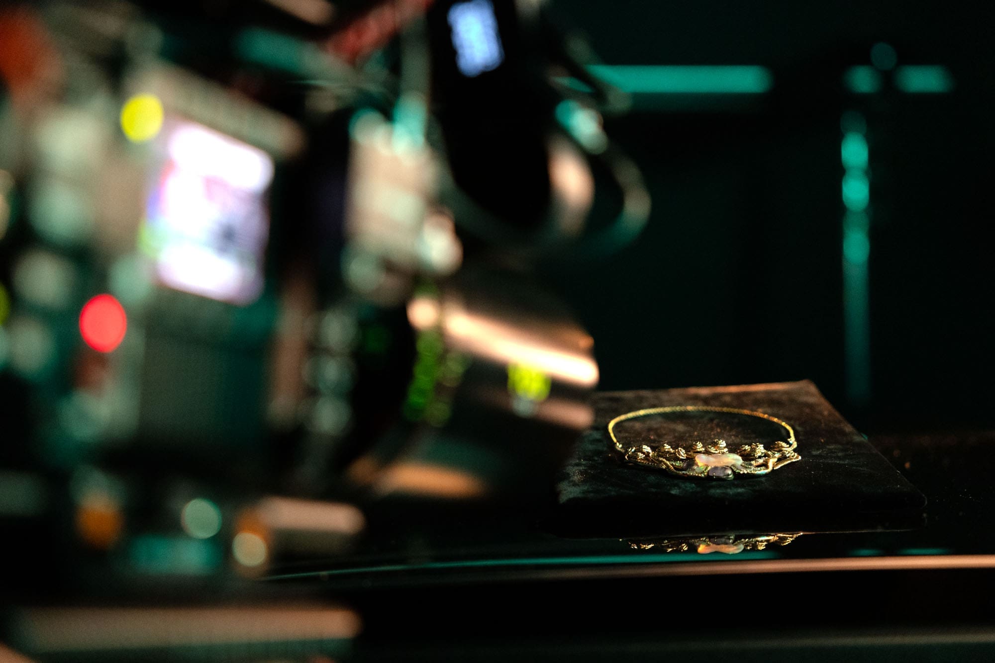 The Medusa pendant under cinematic lighting, captured in a behind-the-scenes moment during filming.