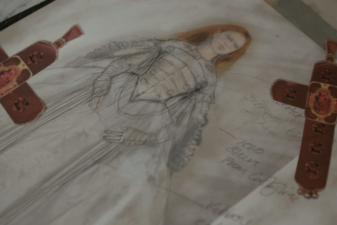 Elizabeth costume drawing with cross motif references pinned around it