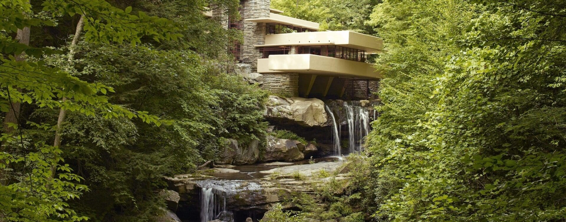 Fallingwater, a house designed by Frank Lloyd Wright, built over a waterfall and surrounded by lush green forest, as seen in 2007.