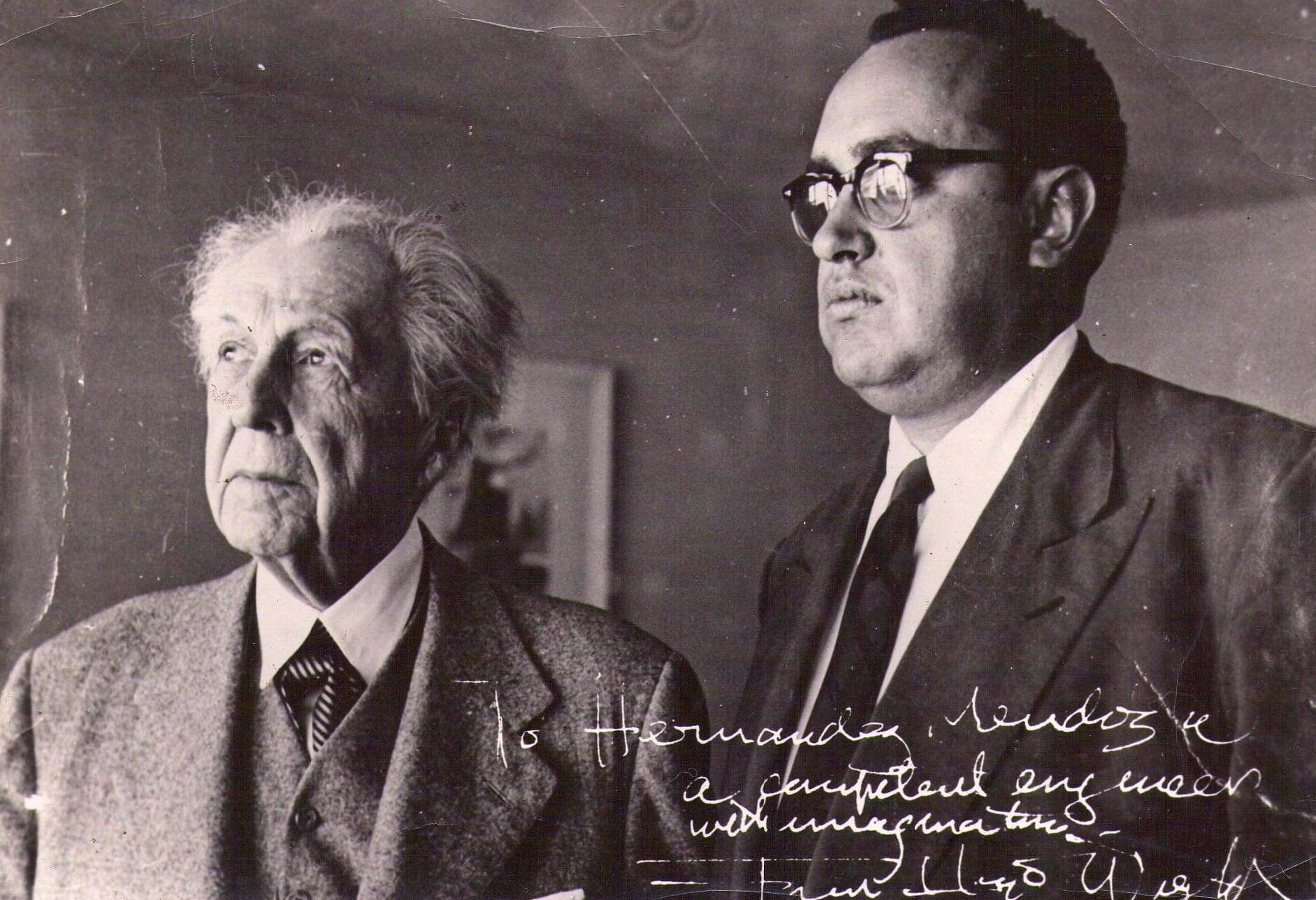 RIOT, NYC Creative Agency: Frank Lloyd Wright with José Luis Hernández Mendoza, a certified engineer, standing side by side in a black and white photograph. Frank Lloyd Wright with José Luis Hernández Mendoza, a certified engineer, standing side by side in a black and white photograph.