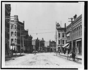 RIOT, NYC Creative Agency: A historical photograph of Front Street, Missoula, Montana, from the early 1900s, showing buildings, carriages, and pedestrians. A historical photograph of Front Street, Missoula, Montana, from the early 1900s, showing buildings, carriages, and pedestrians.