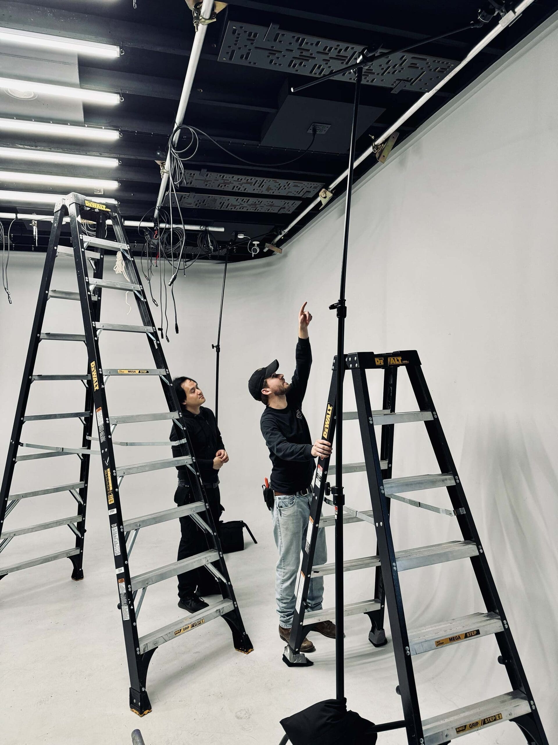 Gaffer and grip installing new rafter mounts for lighting grid at RIOT’s Grove Street Studio.