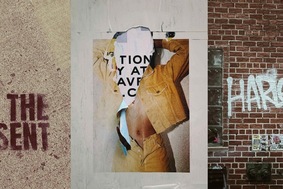 Torn urban collage with graffiti, ripped posters, and the words "LIVE THE PRESENT" stenciled on pavement