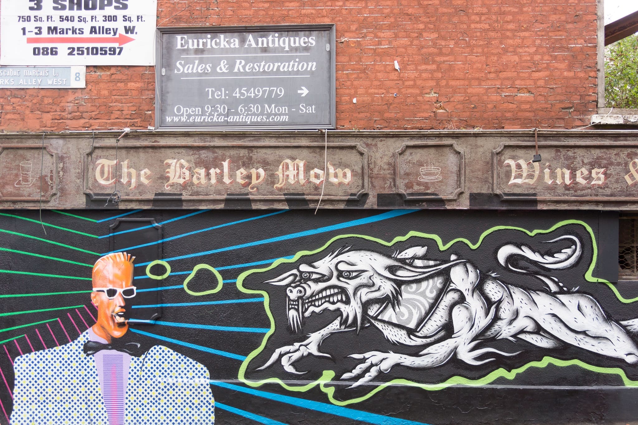 RIOT, NYC Creative Agency: Street art of Max Headroom on a Dublin wall featuring vibrant colors and a dragon-like creature. Street art of Max Headroom on a Dublin wall featuring vibrant colors and a dragon-like creature.
