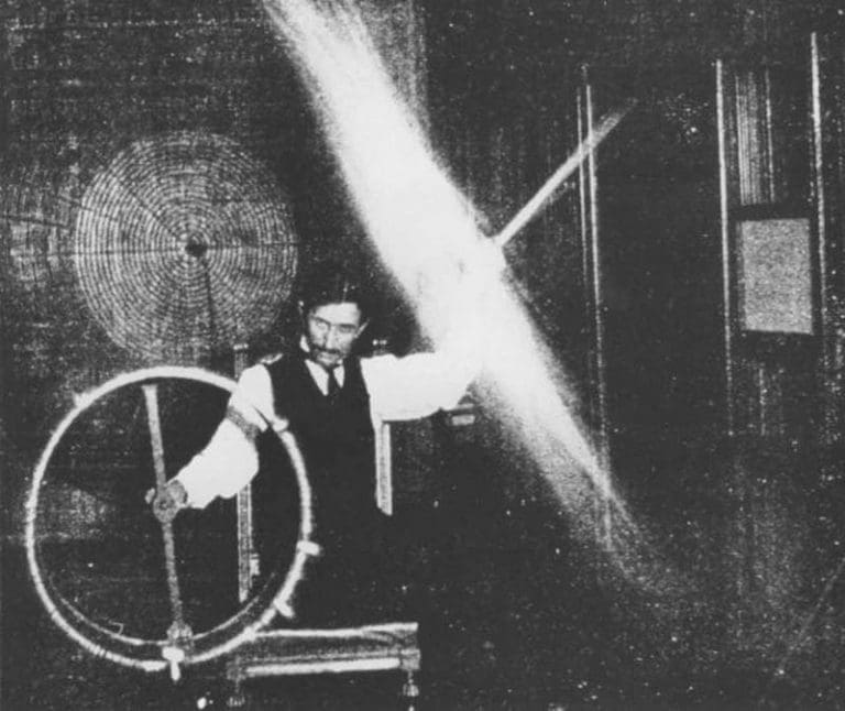 Nikola Tesla conducting an experiment with electrical resonance, surrounded by high-voltage equipment and a large circular coil.