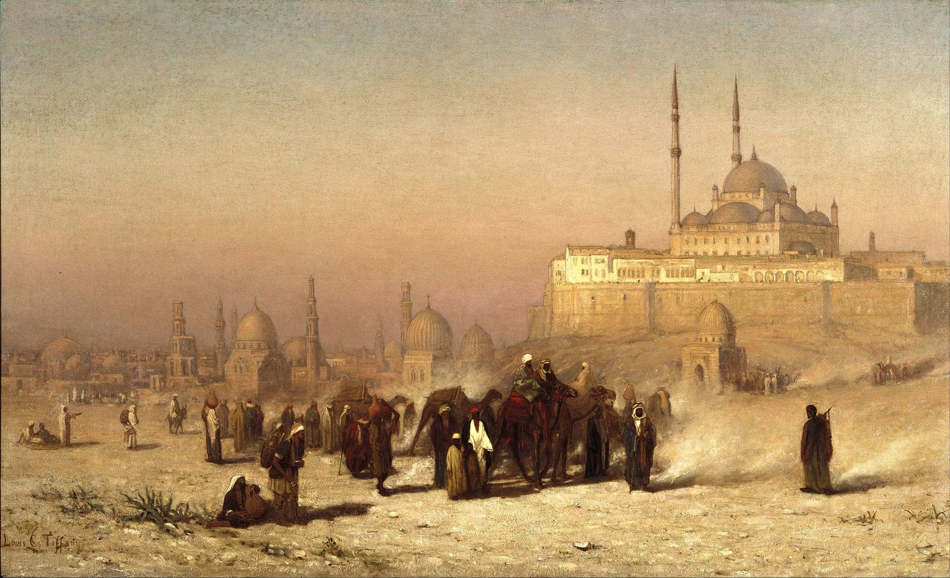 Painting by Louis Comfort Tiffany depicting a desert scene between Old and New Cairo, with the Citadel Mosque of Mohammed Ali and the Tombs of the Mamelukes in the background. Image via Wikimedia Commons.