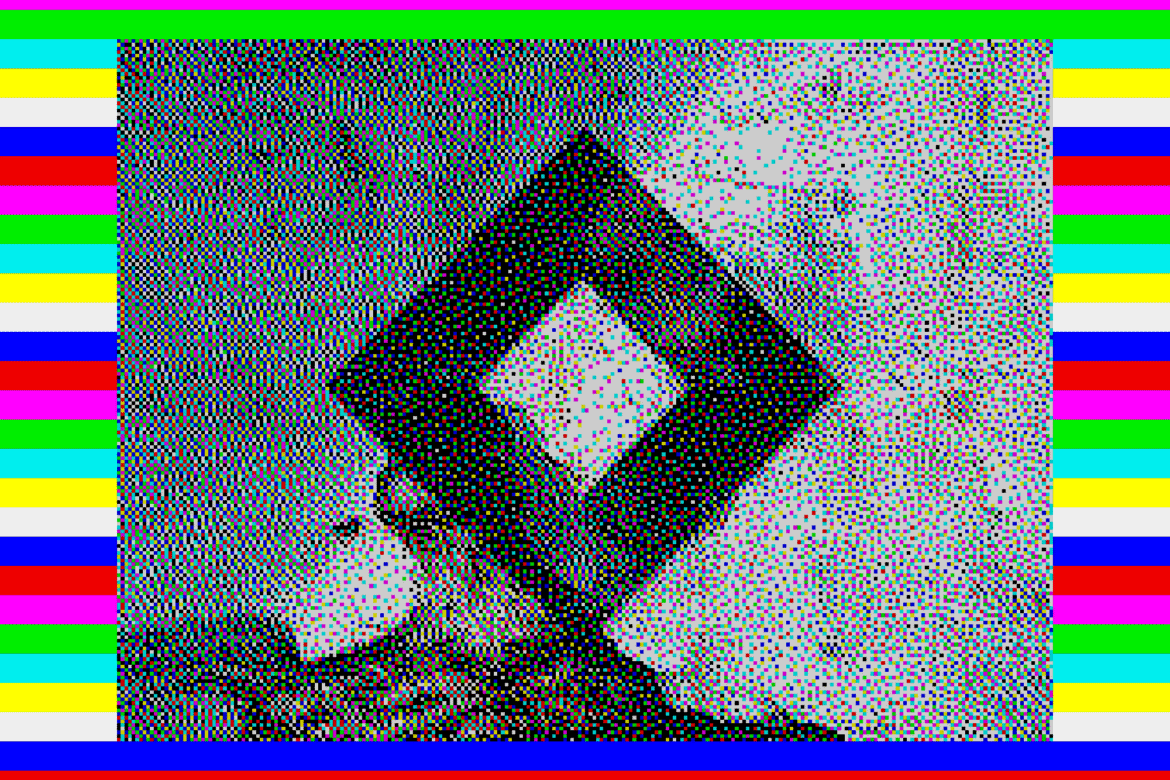 ZX Spectrum–style loading screen of a black hazard diamond on cracked wall with full rainbow border stripes behind the image