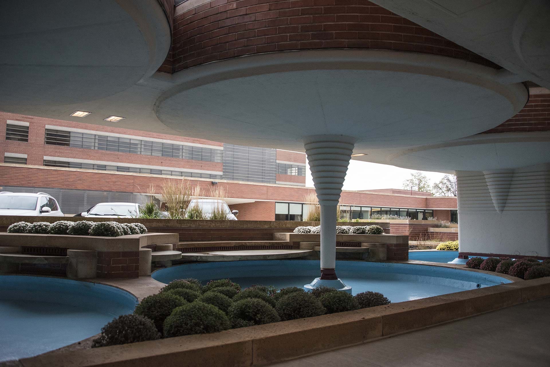 Interior view of the SC Johnson Administration Building designed by Frank Lloyd Wright, featuring large circular structures and planters in the courtyard.