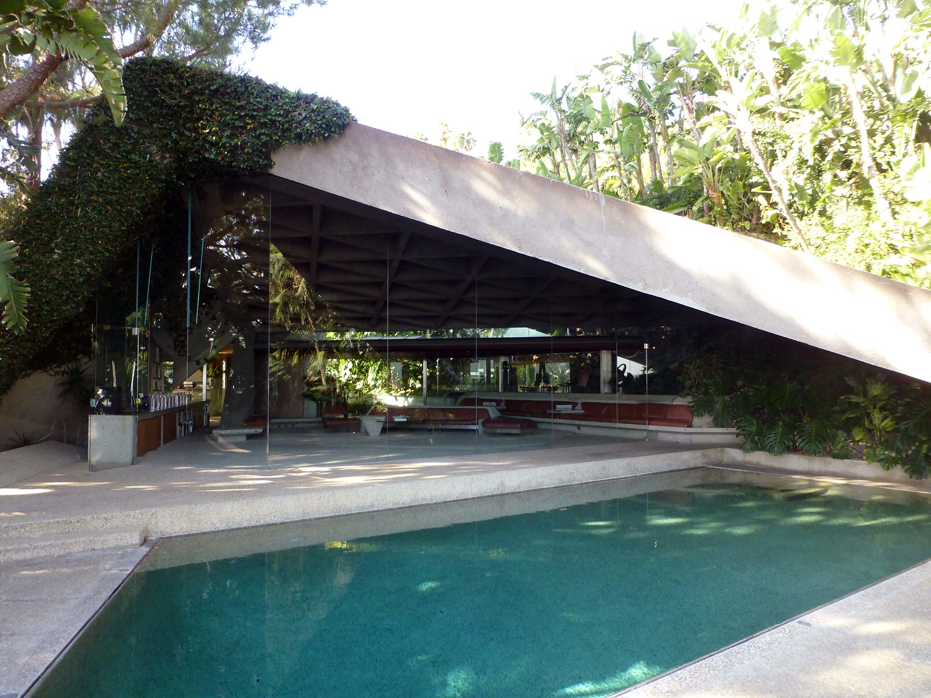 The Sheats-Goldstein Residence, designed by John Lautner, featuring glass walls, concrete structures, and a pool integrated into the landscape.