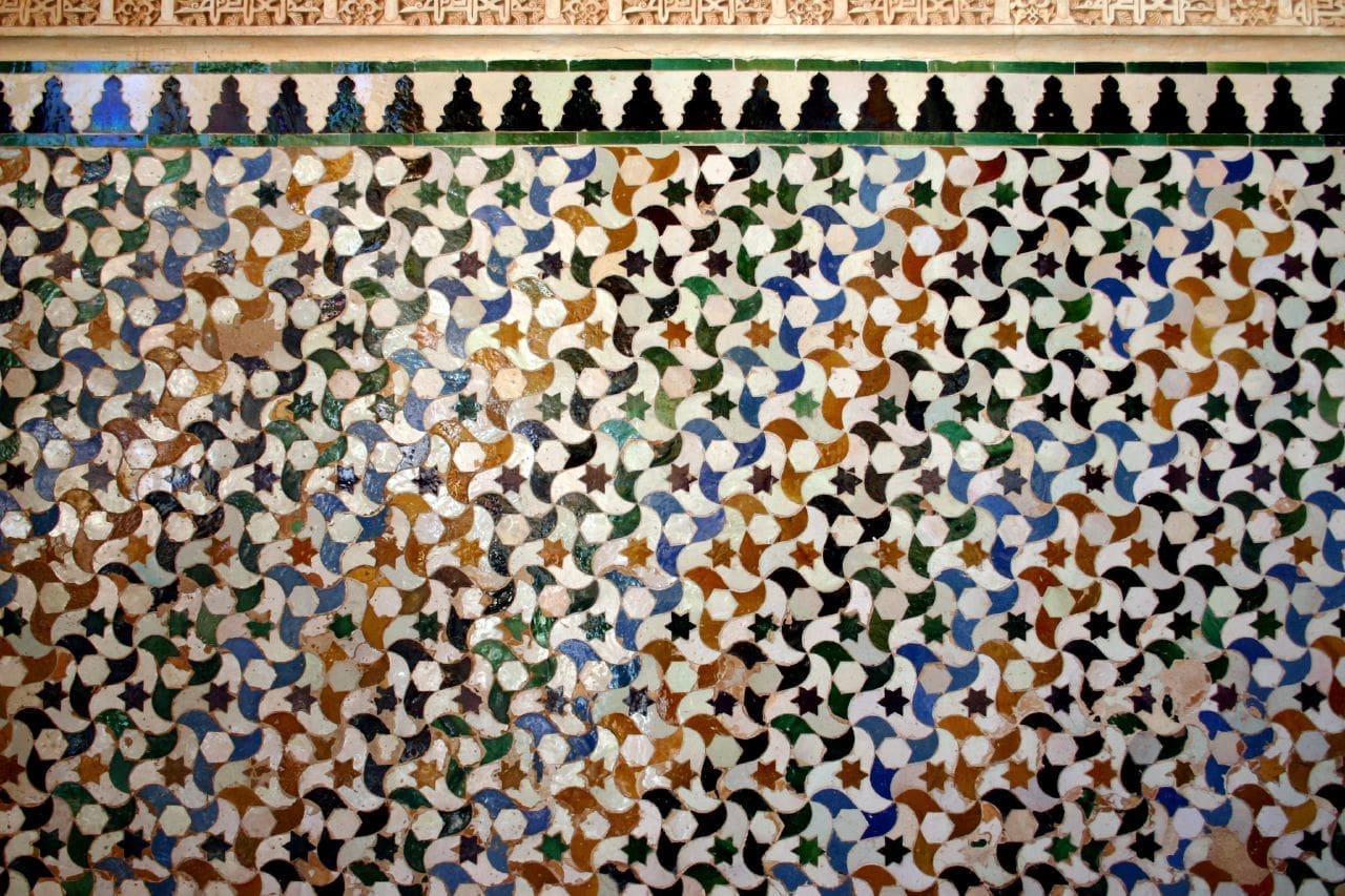 Colorful geometric tessellation patterns found in the Alhambra, showcasing Moorish art and design.