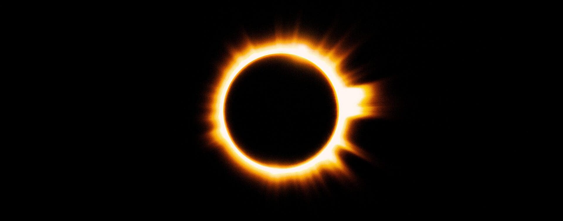 Solar eclipse with a bright orange ring of fire glowing against a black sky in Bleed Electric’s This Is My Masterpiece visuals