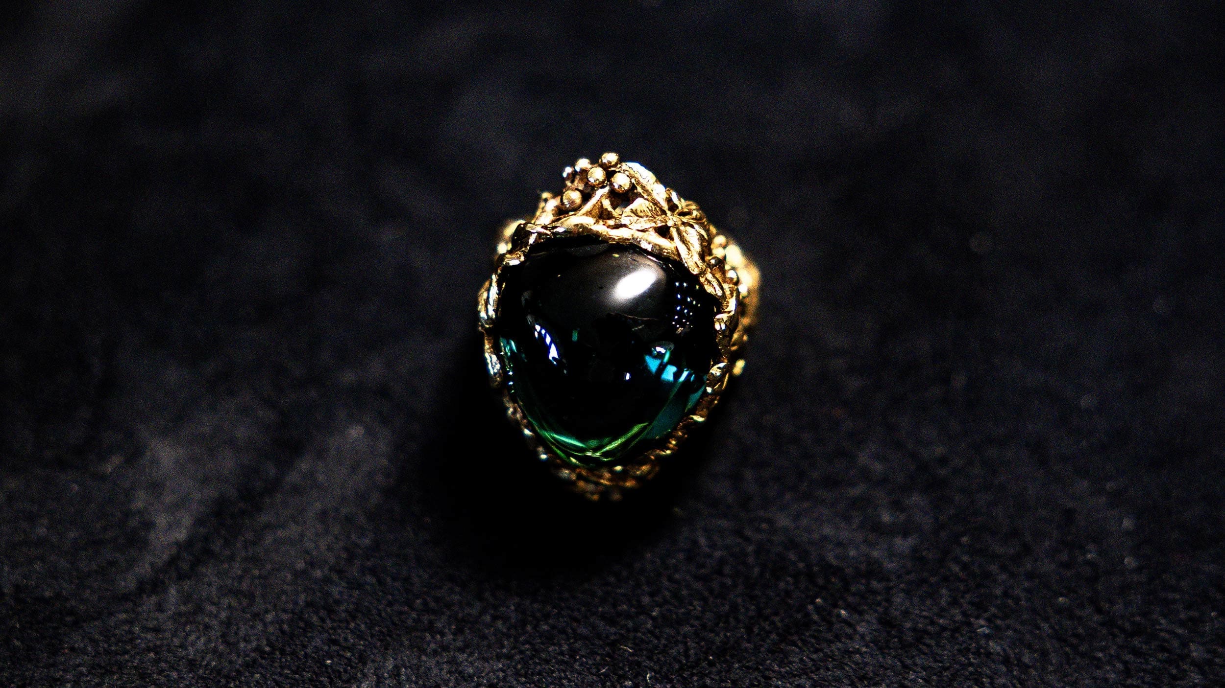 RIOT, NYC Creative Agency: Close-up of an archival Tiffany ring with dark gemstone and ornate gold mounting, captured by RIOT for Tiffany x Frankenstein. Close-up of an archival Tiffany ring with dark gemstone and ornate gold mounting, captured by RIOT for Tiffany x Frankenstein.