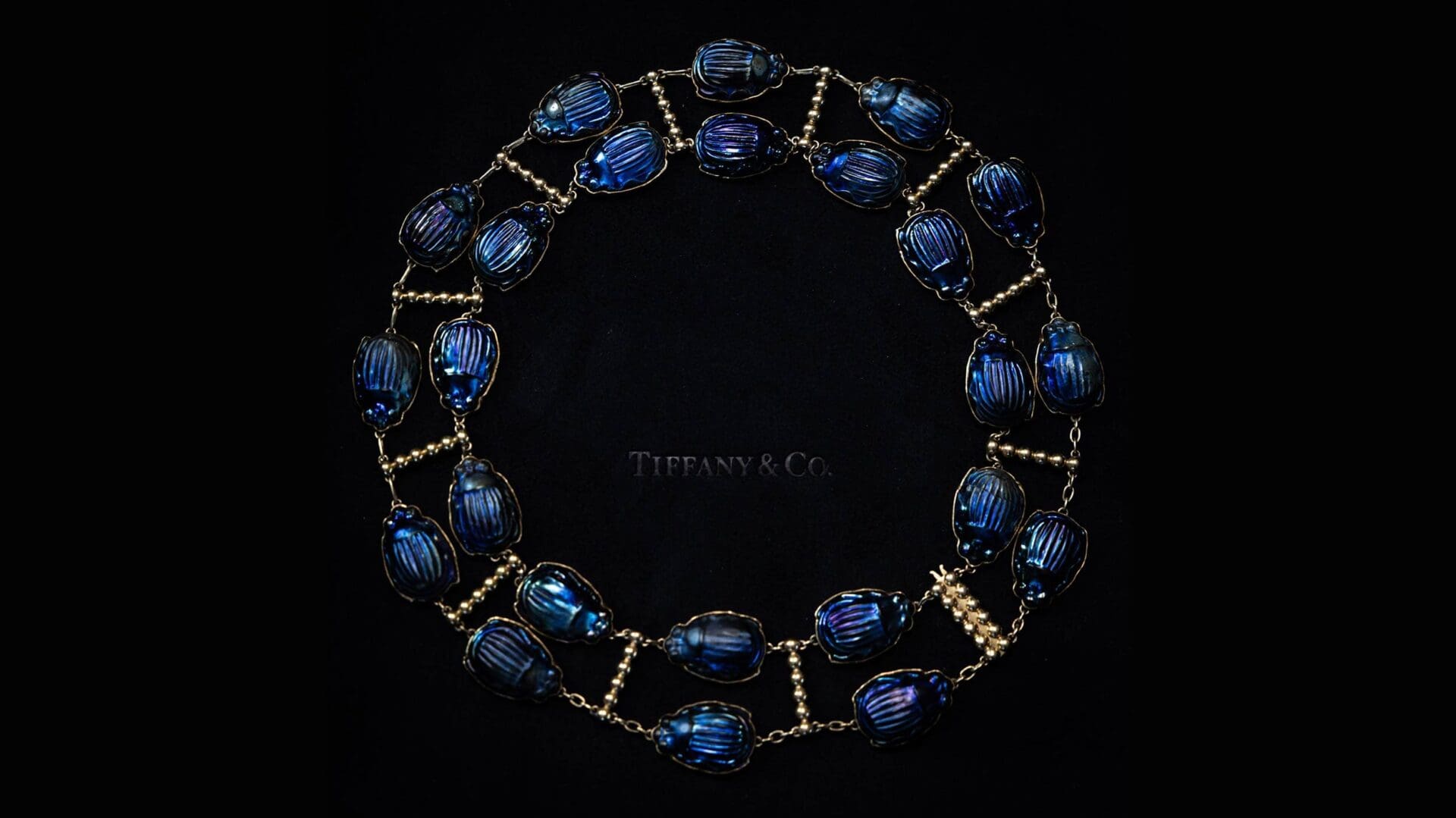 Close-up of an archival Tiffany scarab necklace on black velvet, captured for Tiffany x Frankenstein by RIOT.