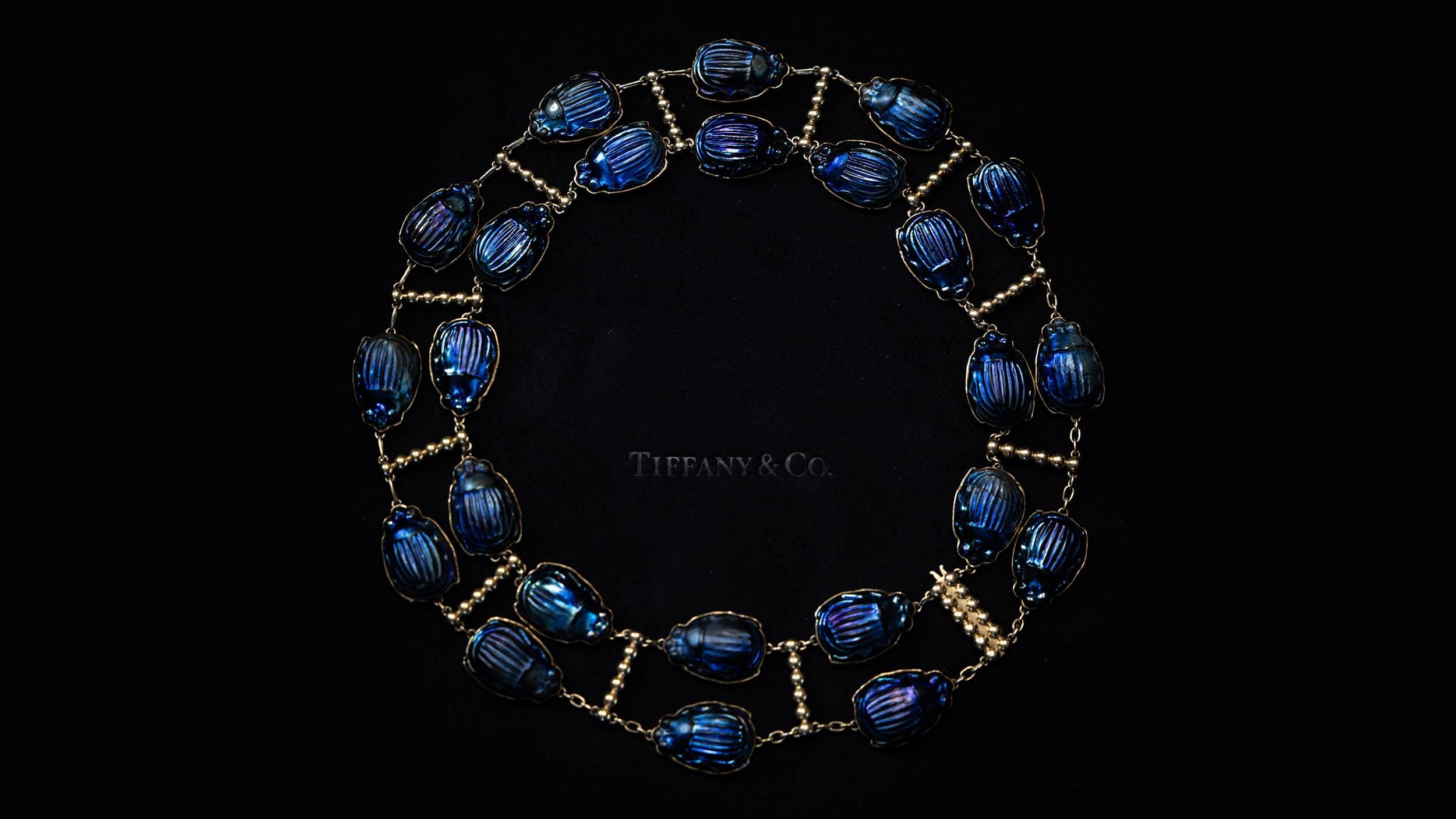 Close-up of an archival Tiffany scarab necklace on black velvet, captured for Tiffany x Frankenstein by RIOT.