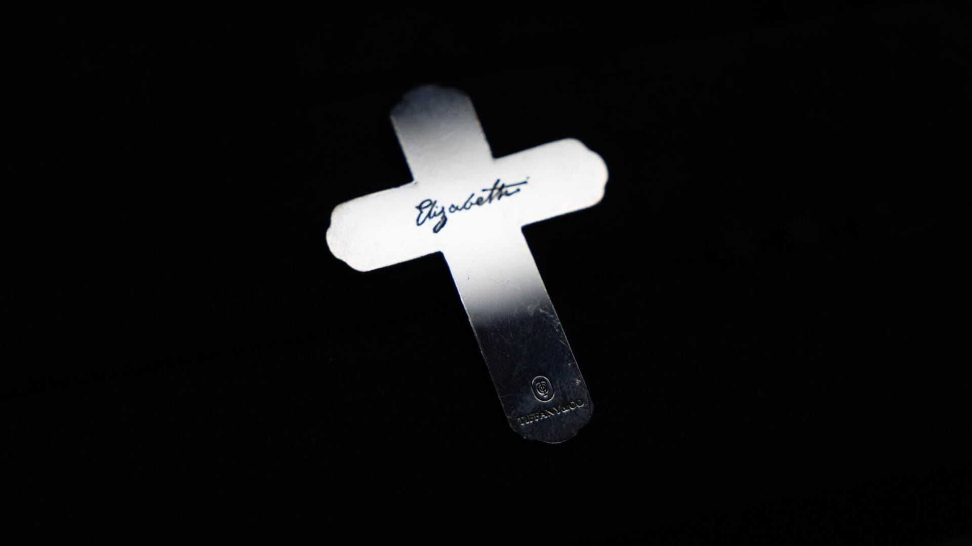 Close-up of Tiffany & Co.’s silver cross engraved with “Elizabeth,” created for Guillermo del Toro’s Frankenstein and photographed by RIOT.
